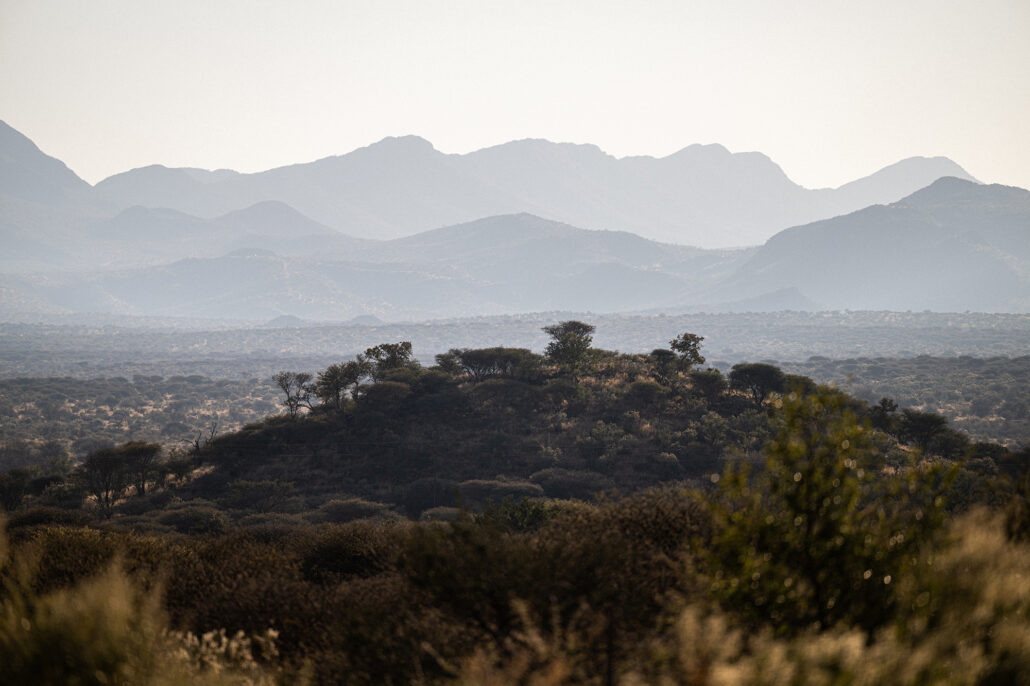 Wide Namibian sky and rugged mountain range seen from the passenger seat.
