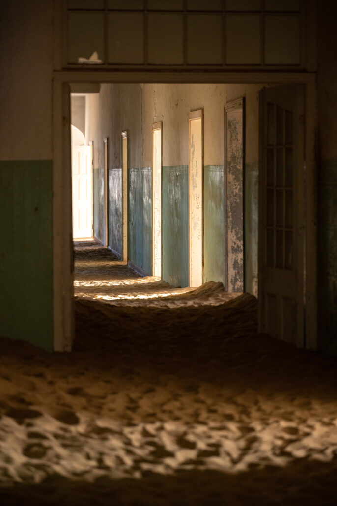 Remains of the old Kolmanskop hospital with sand-drifted corridors.