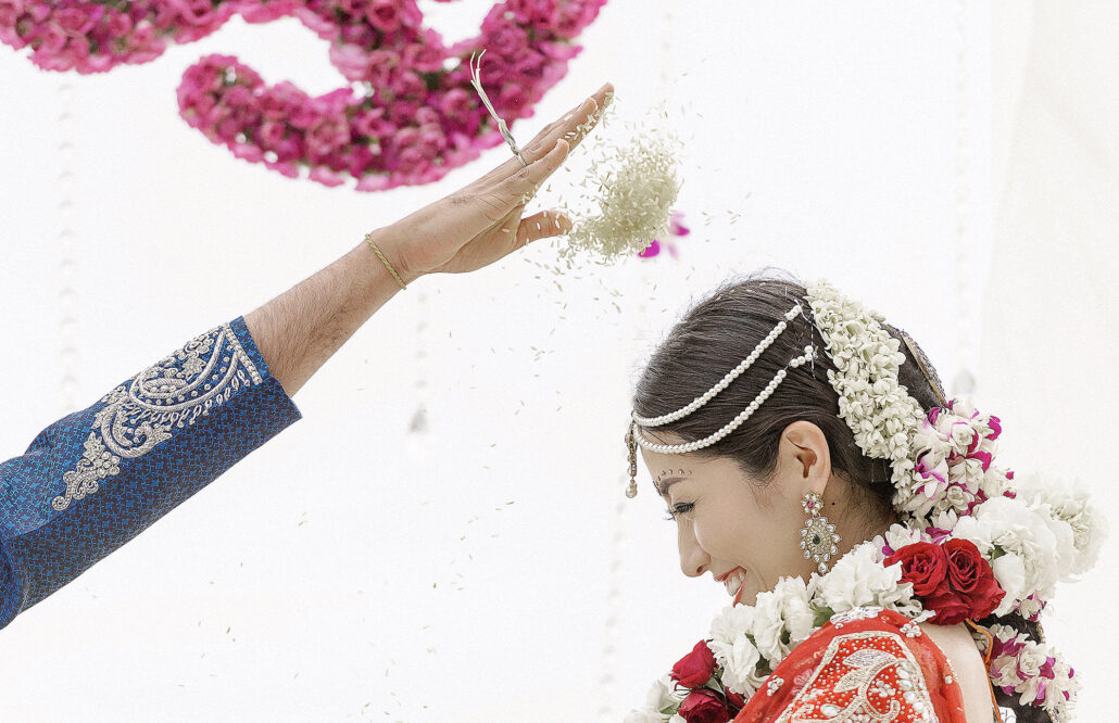 Indian wedding ceremony moment with rice toss, edited using AI editing software for photographers for authentic skin tones and vivid cultural detail.