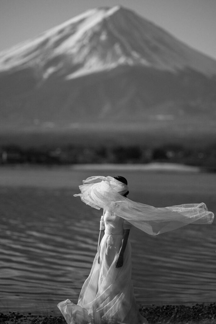A Vogue featured wedding at Mt Fuji in Japan. The bride's veil windblown with Mt Fuji behind.