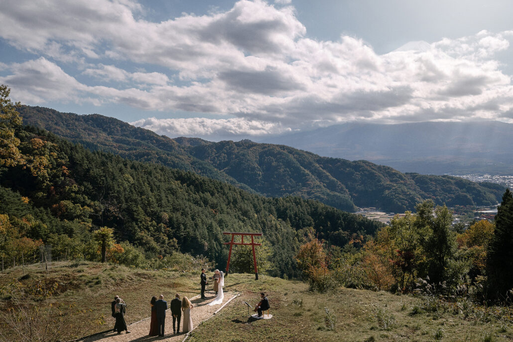 Red torii gate overlooking Mount Fuji under a blue sky, symbolizing serenity and sacred connection. A breathtaking view from the "Tori in the sky" (Tenku no Torii) shrine where a micro wedding took place, blending Japan’s spiritual beauty with timeless romance.