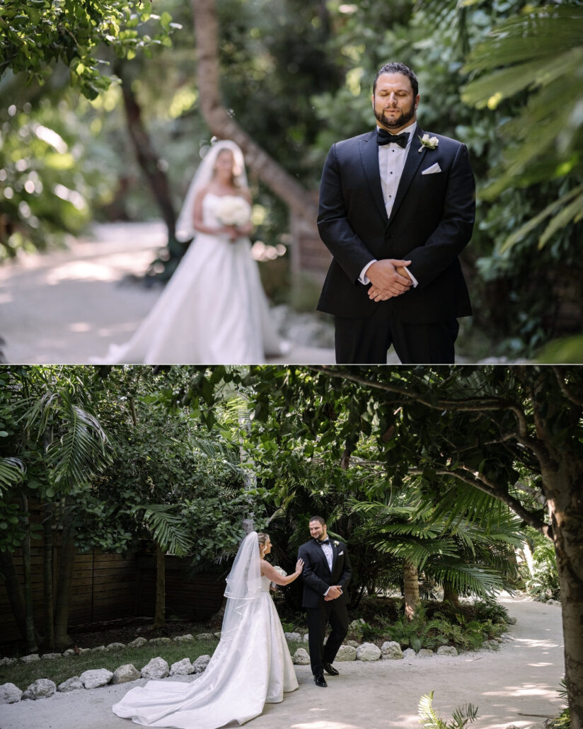 The groom waits on a garden path with his eyes closed as the bride walks up behind him and touches his shoulder, their first look on Little Palm Island.