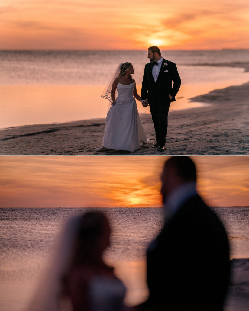 The couple hold hands on the shore as an orange sun sets over the water, and their silhouettes blur against the evening sky of the Florida Keys.
