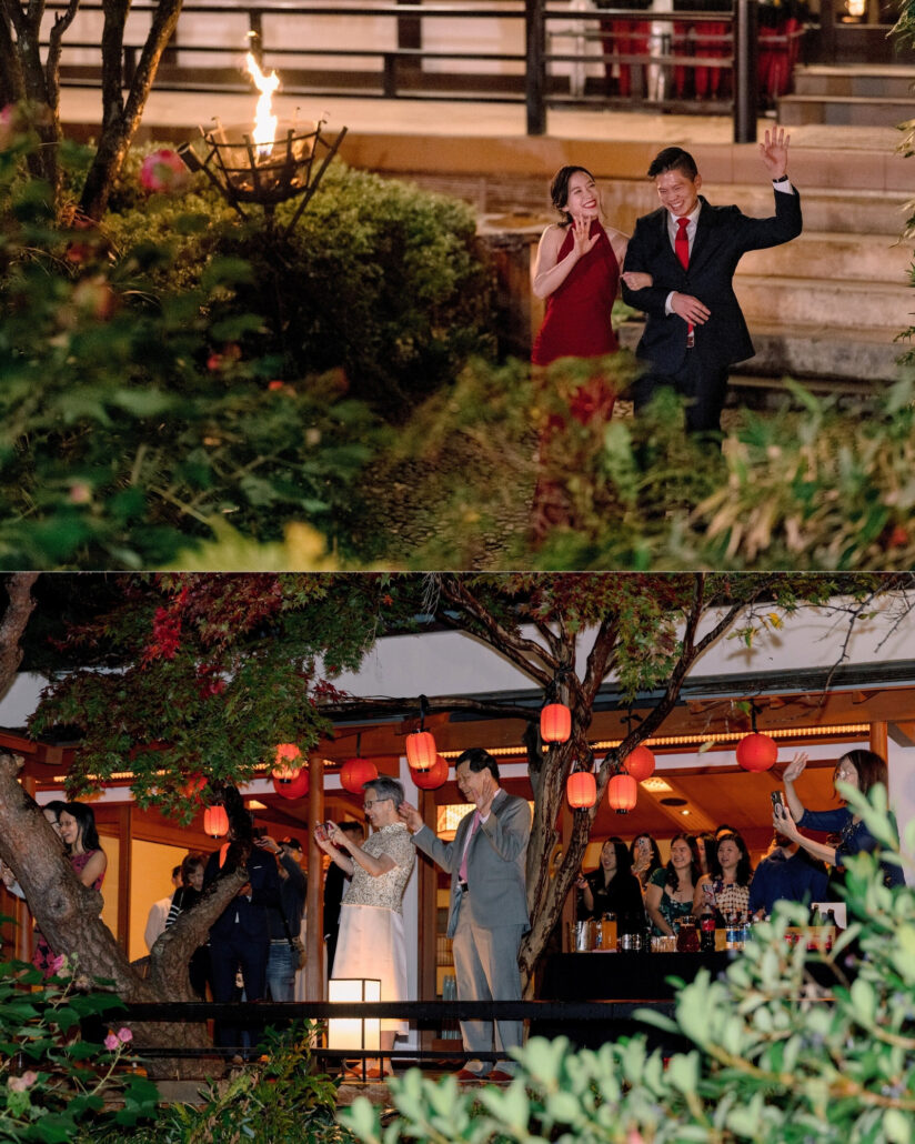 The bride in red and the groom wave as they arrive at their destination wedding welcome party, and guests cheer from a terrace hung with red lanterns.