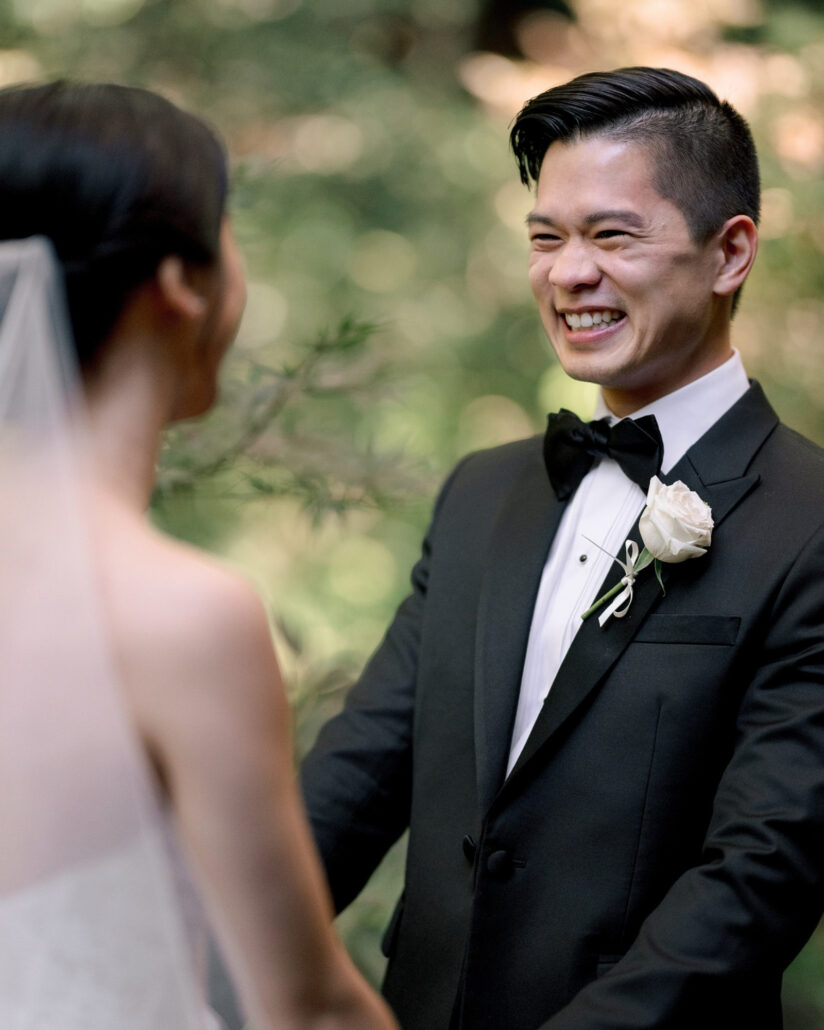 The groom grins wide as he faces the bride at their first look in the garden of a traditional ryokan in Japan.