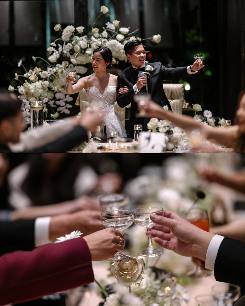 The couple raise their glasses at the sweetheart table among white florals, and guests clink coupes during the toasts at their destination wedding reception.
