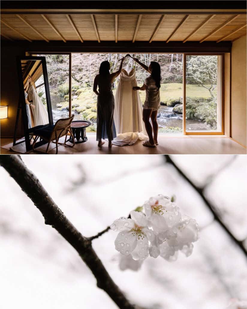 Two friends lift the wedding dress on its hanger against a garden window at Asaba ryokan, and white cherry blossom holds raindrops on a branch.