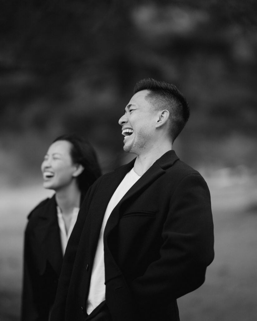 The engaged couple laugh together, faces close, in black and white on their Mount Fuji proposal day.