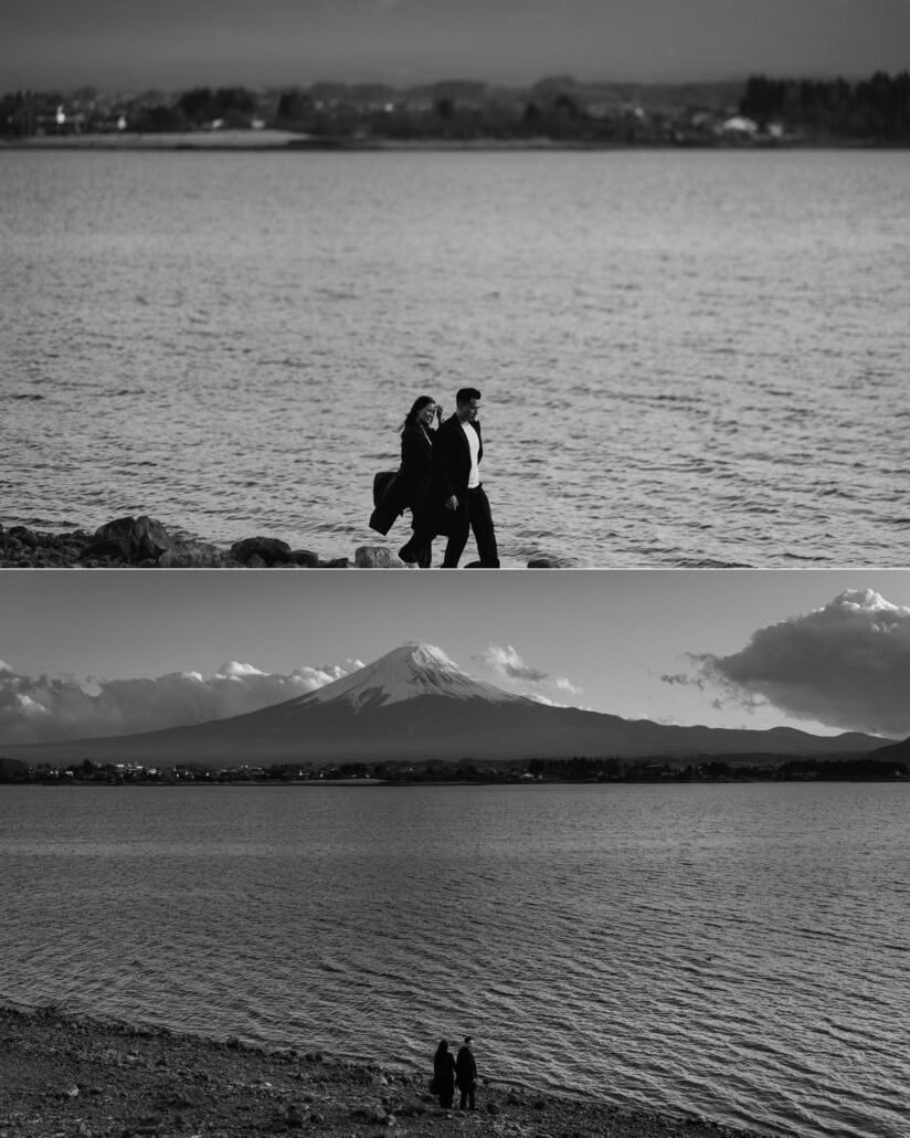 The couple walk the shore of Lake Kawaguchiko, and stand tiny at the water's edge with Mount Fuji across the lake, in black and white.