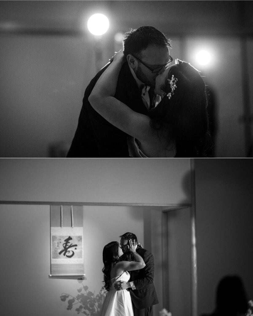 The bride and groom kiss in black and white at Asaba ryokan, backlit by two lamps, and again beside a hanging calligraphy scroll.