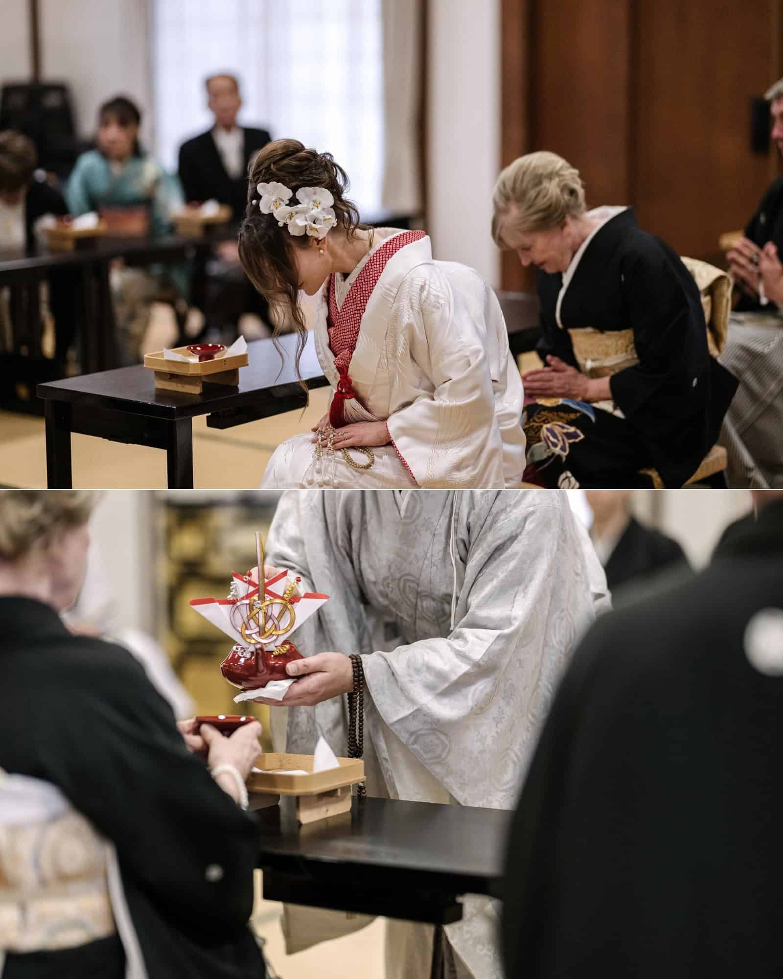 The bride bows during a Buddhist temple wedding in Japan, and a priest in white robes holds a decorated sake vessel over a red lacquer cup.