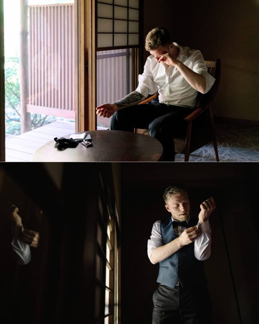 Getting ready for a ryokan wedding in Japan, the groom wipes his eye in a chair by an open shoji door, then fastens his cuffs in a blue waistcoat.