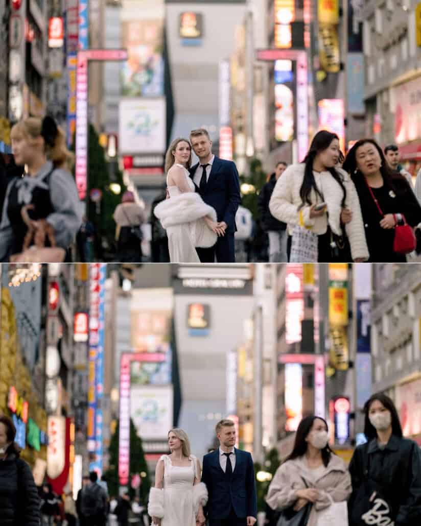 The couple stand still as the crowd flows past on a neon lined Shinjuku street, then walk down it together ahead of their Japan elopement.