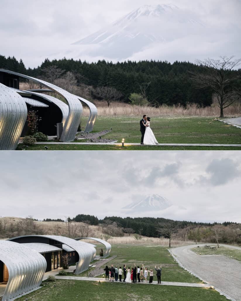 Mt Fuji appears above the arched roofs at dusk as the couple kiss on the lawn of their Mt Fuji winery wedding, then guests wave toward the mountain.
