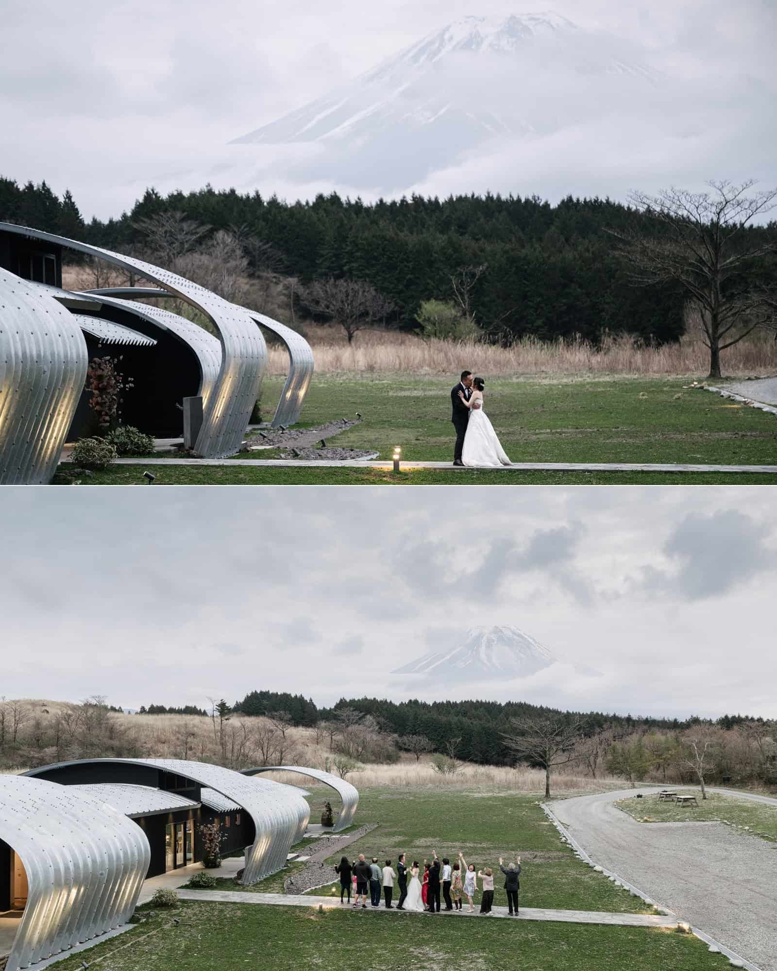 Mt Fuji appears above the arched roofs of Fujisan Winery at dusk as the couple kiss on the lawn, then guests wave toward the mountain on a destination wedding weekend in Japan.