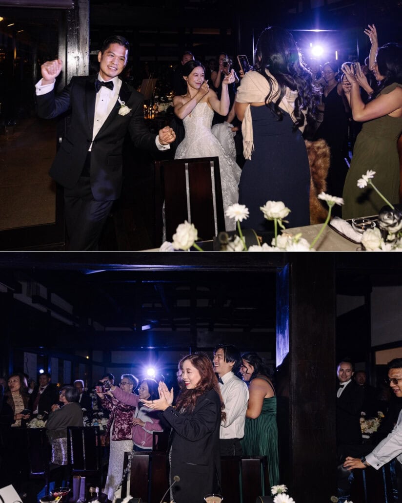 The groom punches the air as he and the bride enter their wedding reception past guests filming on phones, then guests clap against a spotlight.