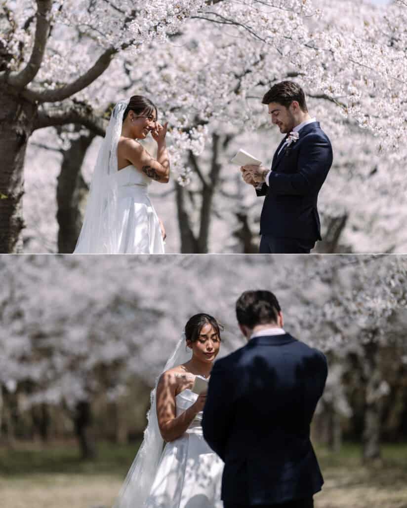 The bride wipes her eyes as the groom reads his vows, and then reads her own to him under the cherry blossoms.