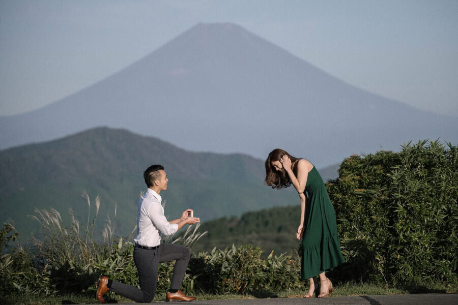 He proposes again on Taikanzan with Mt Fuji huge behind them, and she bends forward with her hand to her face.