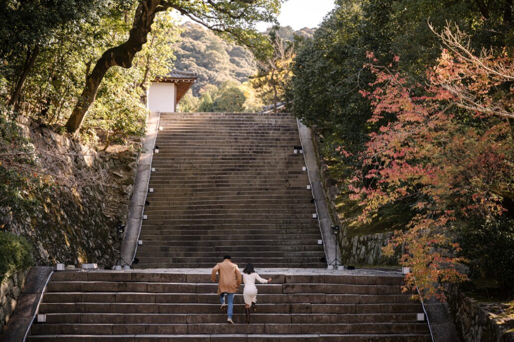 The couple run up the long stone stairway at Chion-in temple in Kyoto as the maples turn.