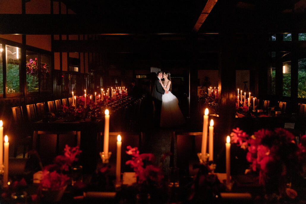 The bride and groom alone in the candlelit reception room before their guests come in.