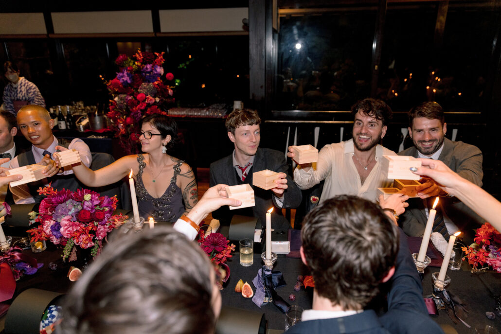 A table of guests raises masu in a toast at the wedding reception at Jinya.