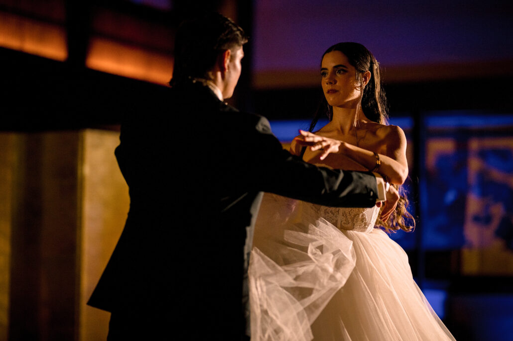 The groom leads the bride through their waltz across the floor.
