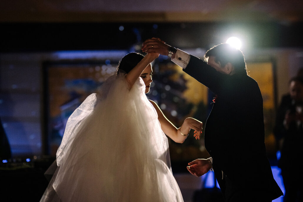 The bride spins under the groom's arm in their first dance.