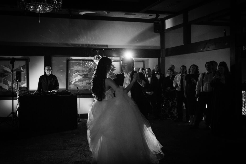 In black and white, the bride mid-spin, the groom close by.
