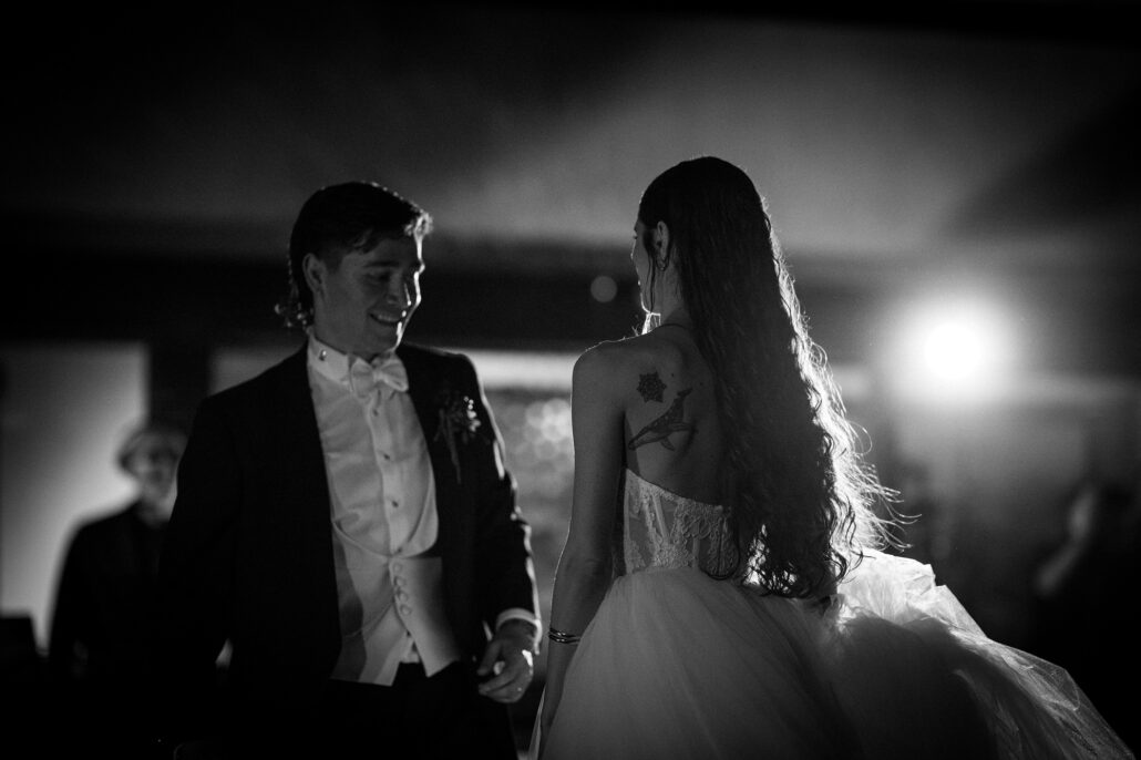 In black and white, the couple close together during their first dance.