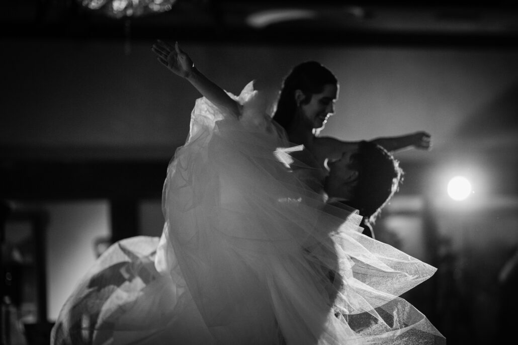 In black and white, close on the lift, her gown flying.
