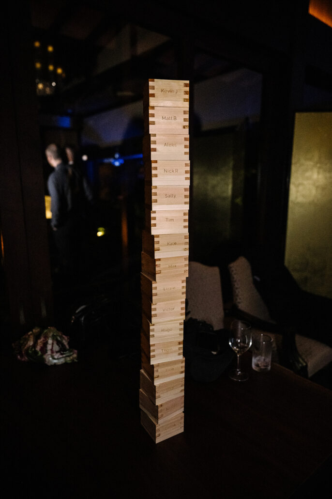 A tall tower of wooden blocks from a giant stacking game stands in the dark of the reception room.