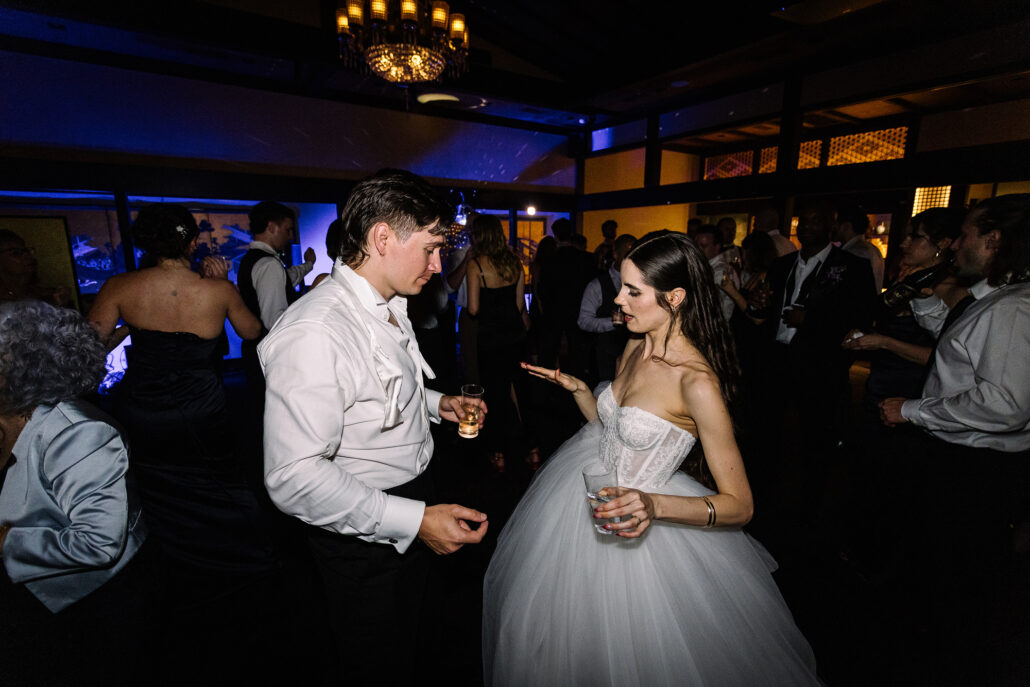 The newlyweds dance in the middle of the crowd, the room glowing gold and blue.
