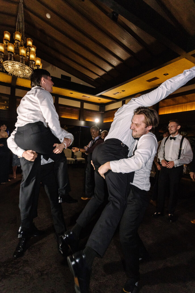 A guest hoists another onto his back on the dance floor.