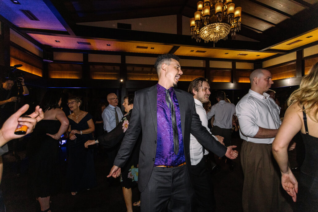 A guest in a purple shirt dances among the crowd.