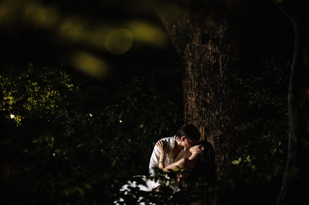 The couple small at the foot of the great tree at night.