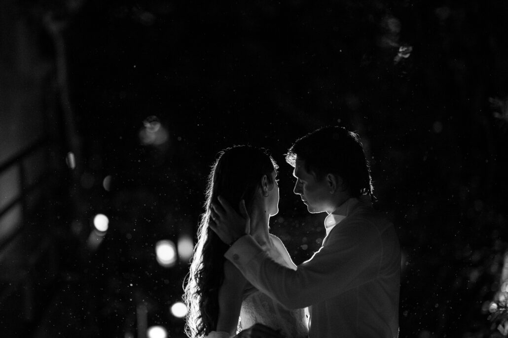 In black and white, a close embrace in the garden at night.