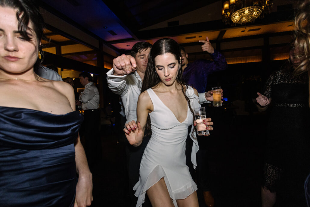 The bride on the late night dance floor, friends all around her.