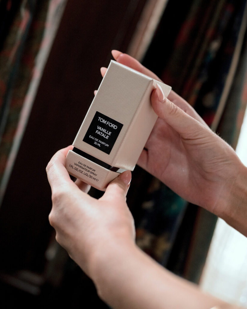 Hands lift a boxed fragrance from its packaging while getting ready on the morning of the snow wedding in Hakuba.