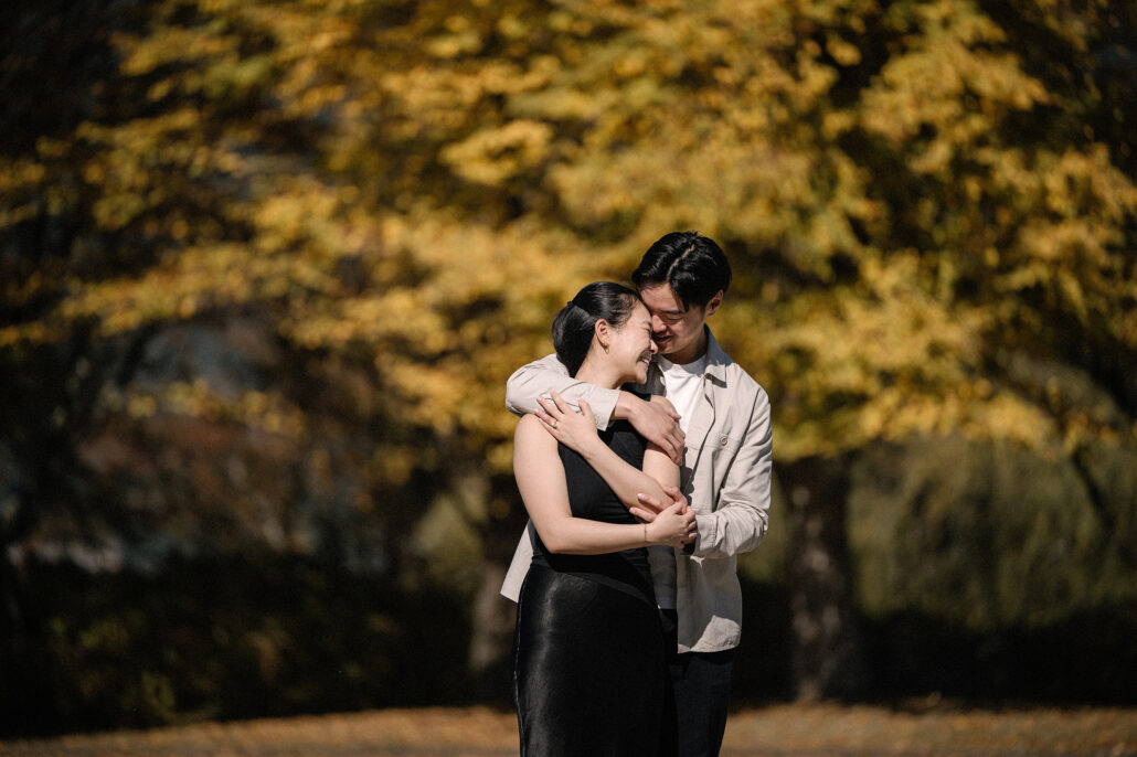 He wraps his arms around her from behind under a canopy of yellow autumn leaves, the last portrait of a morning near Mt Fuji.