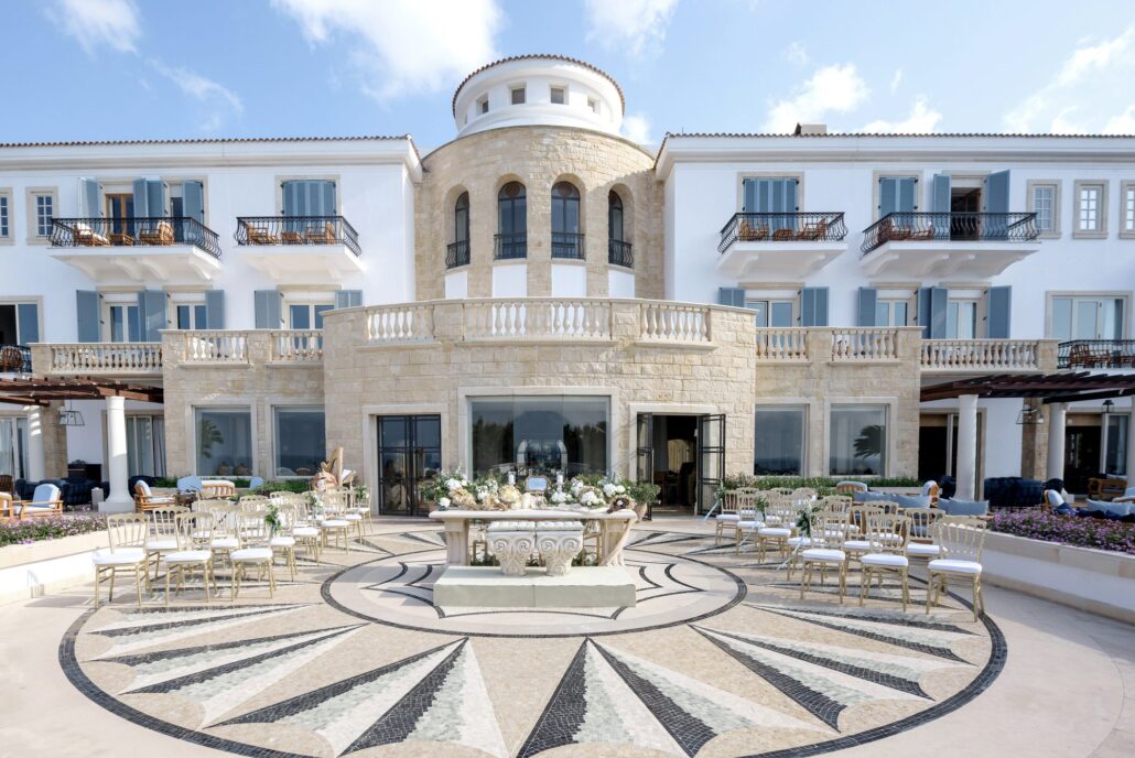 Tables set for a wedding reception on the mosaic terrace in front of Anassa, a white seaside resort in Cyprus.