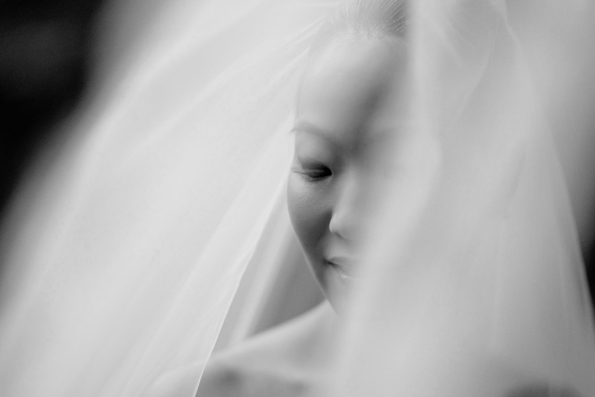 In black and white, the bride closes her eyes beneath the soft folds of her veil on her wedding day at Jinya Ryokan.