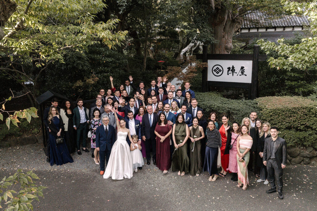The whole wedding party gathers for a group photograph at the entrance to Jinya, the ryokan where they celebrated.
