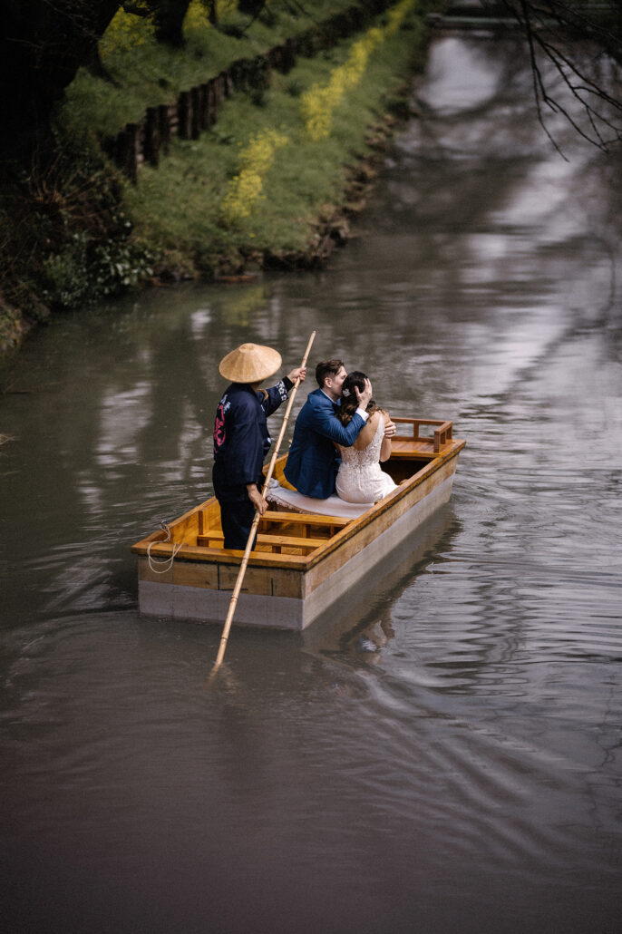 On the same date a year later, another couple ride a wooden boat down the same river in Kawagoe, the cherry trees above still in bud.
