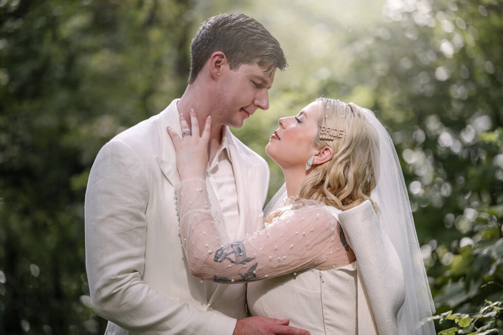 The bride lifts her face to the groom in hazy summer light, a close portrait from an elopement in a Japanese garden.